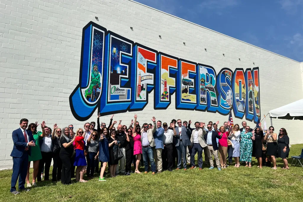 A crowd in front of the Jefferson lettering mural on a blank wall